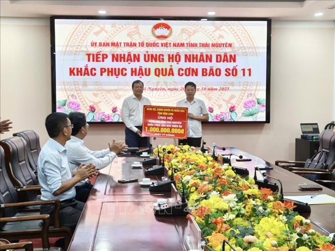 Đại diện Ủy ban Mặt trận Tổ quốc Việt Nam tỉnh Thái Nguyên tiếp nhận tiền ủng hộ đồng bào bị ảnh hưởng của bão lũ từ đoàn công tác tỉnh Vĩnh Long. Ảnh: TTXVN.