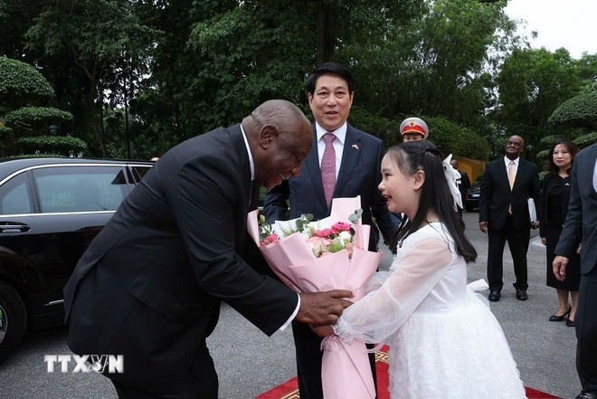 Thiếu nhi Thủ đô Hà Nội tặng hoa chào đón Tổng thống Nam Phi Matamela Cyril Ramaphosa. Ảnh: TTXVN