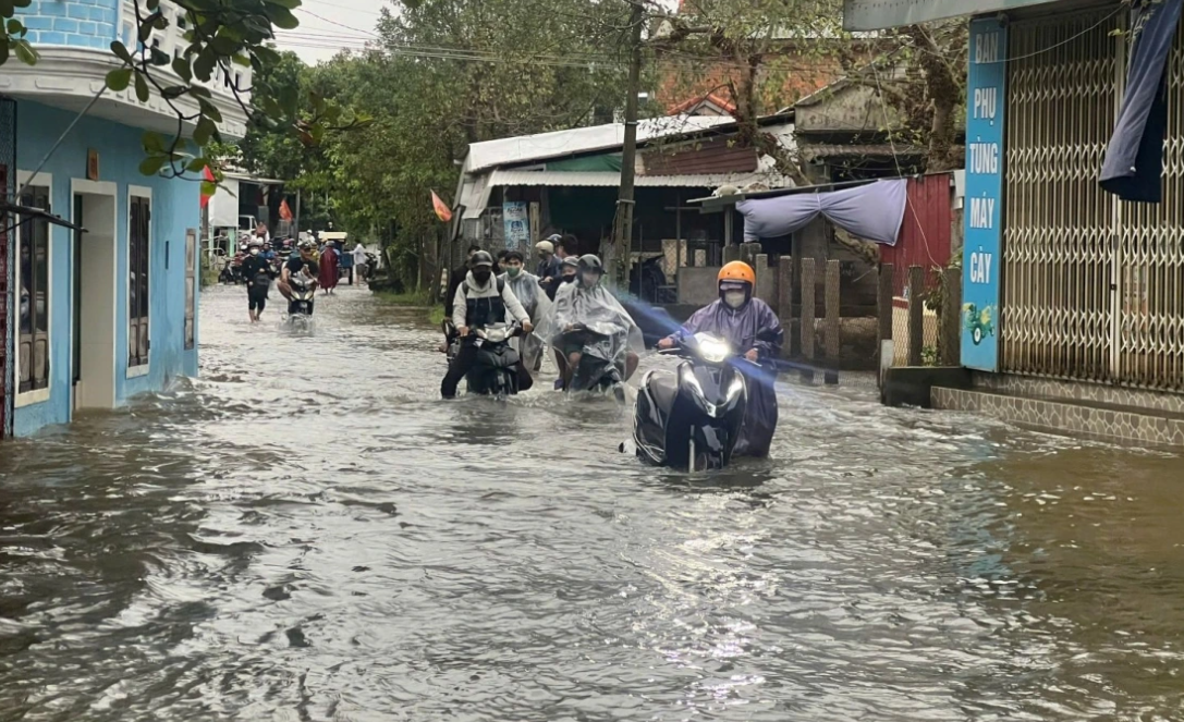 Người dân vất vả khi lưu thông qua các tuyến đường bị ngập sâu