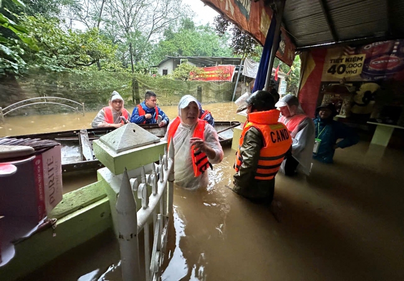 Công an phường Vỹ Dạ, thành phố Huế lội nước lũ đến nhà dân để hỗ trợ. Ảnh: Hải Lan