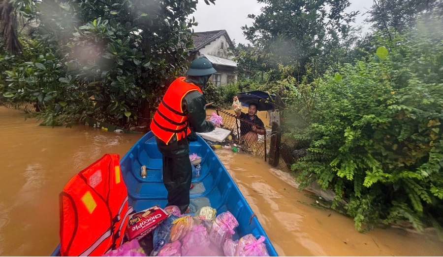 Lực lượng chức năng vào các vùng ngập nặng ở phường An Cựu hỗ trợ mì tôm, nước uống, thuốc men cho người dân