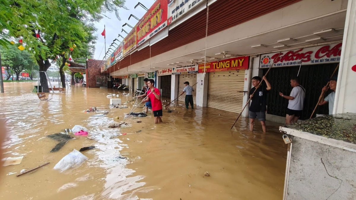 Người dân tranh thủ lúc nước tạm rút để dọn vệ sinh khu phố, nhà cửa