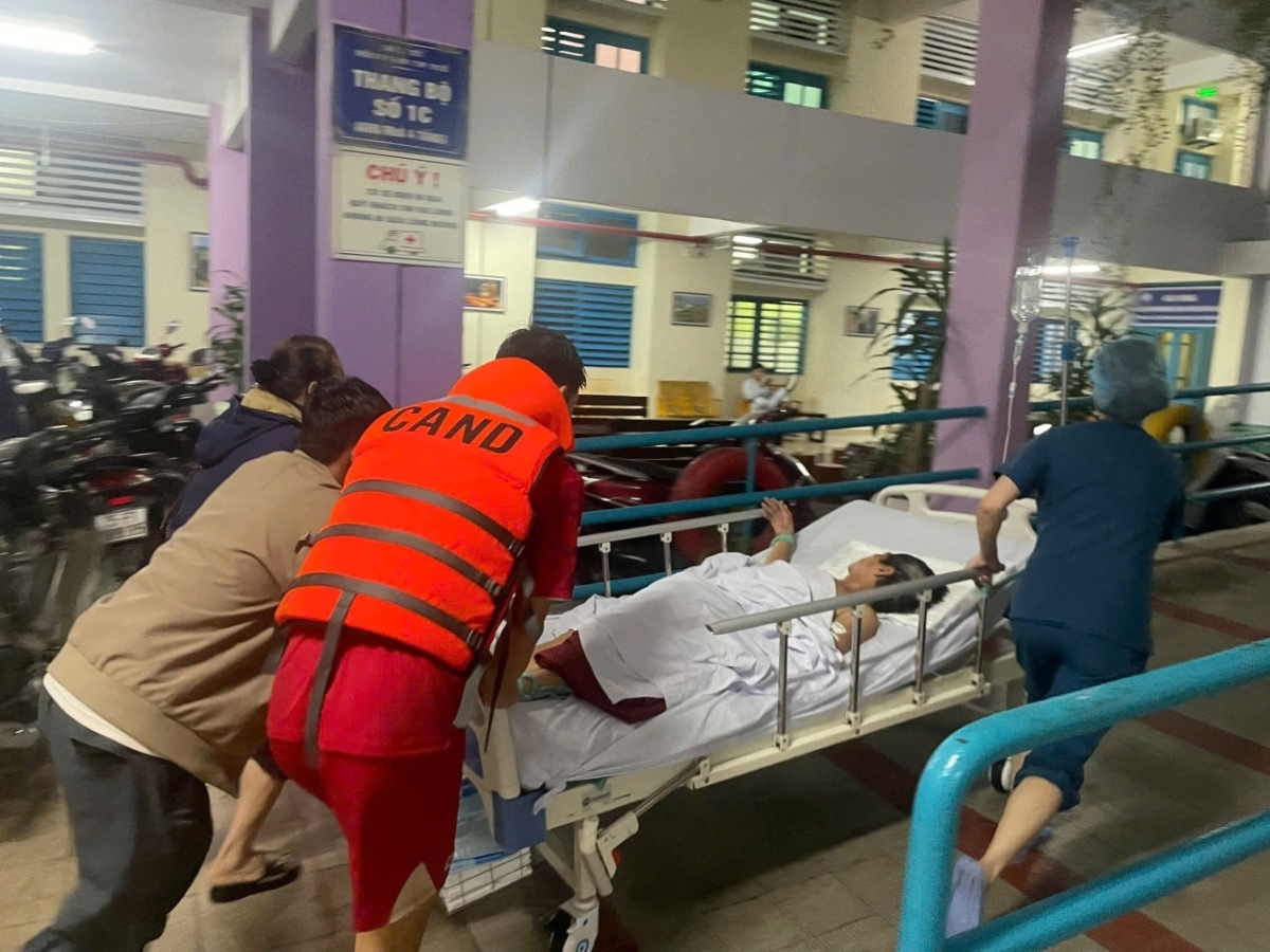 Bác sĩ và chiến sĩ bộ đội, công an phối hợp di chuyển bệnh nhân nặng ra khỏi khu vực ngập