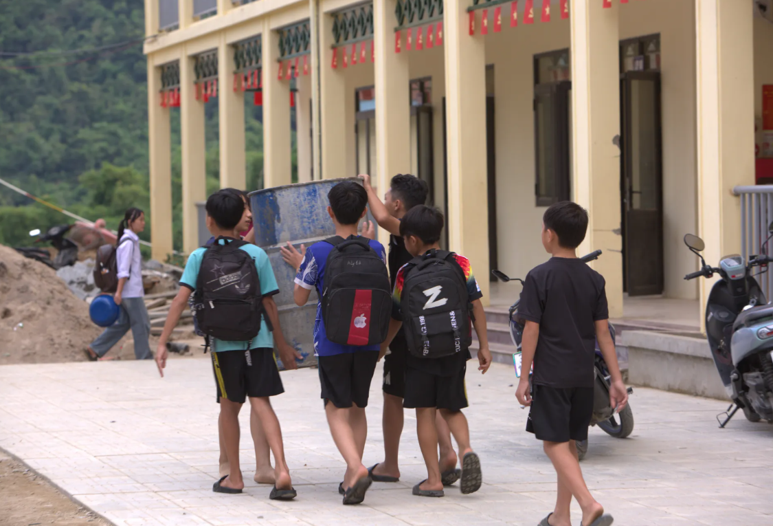 Tranh thử tan học, các em tranh thủ mang dụng cụ ra suối để tắm, giặt trước khi trời tối