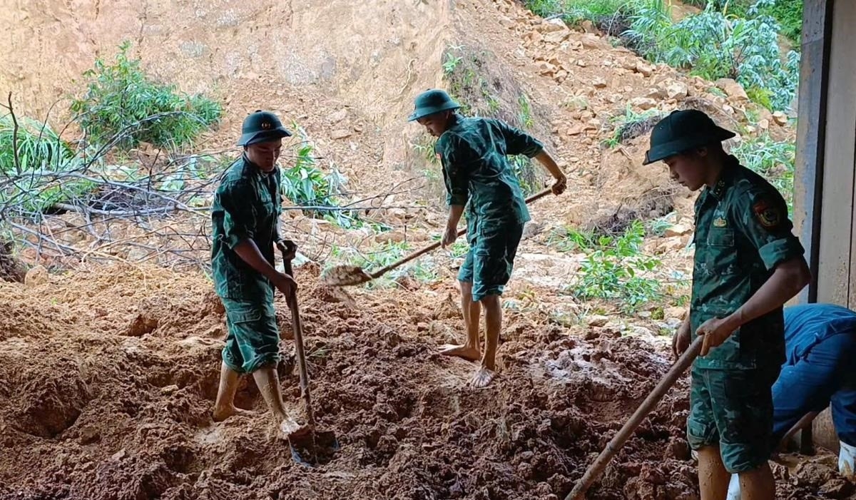 Cán bộ Đồn Biên phòng cửa khẩu A Đớt và các lực lượng thu dọn khối lượng đất sạt lở.