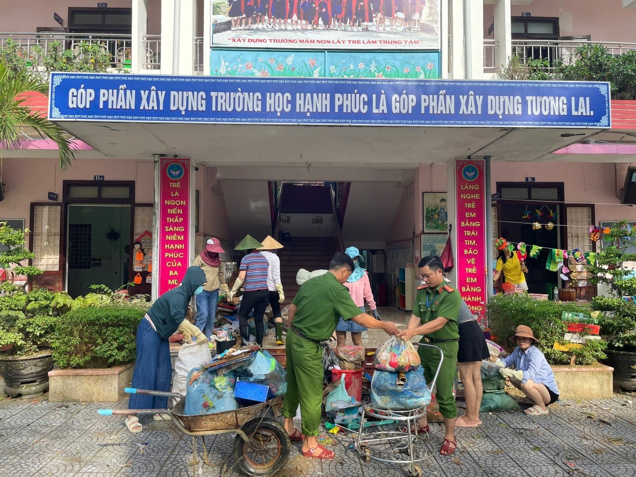 Cán bộ, chiến sĩ công an hỗ trợ các trường học dọn vệ sinh thu gom rác thải, làm sạch môi trường.