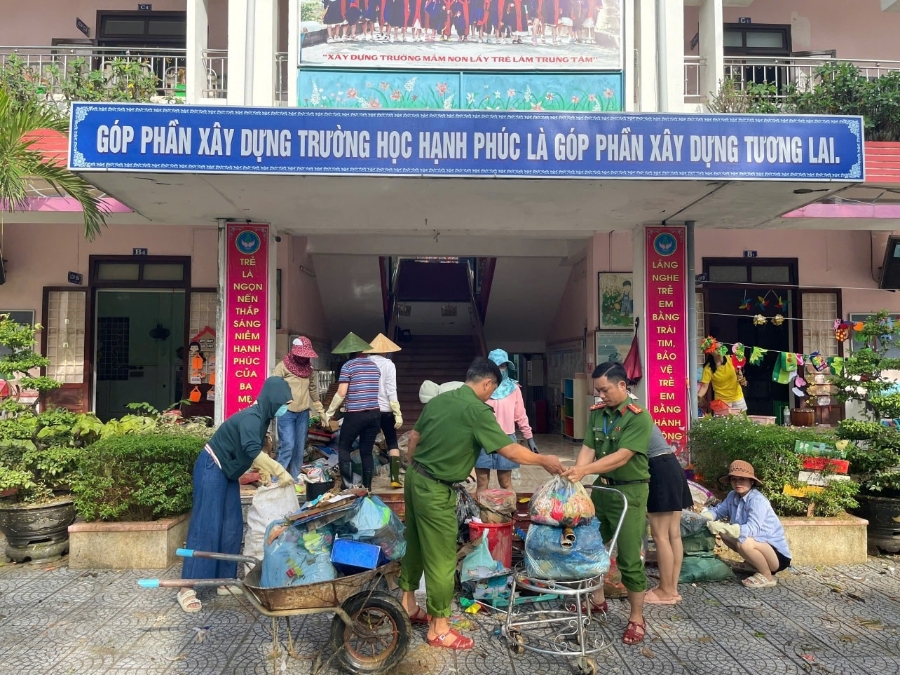 Cán bộ, chiến sĩ công an hỗ trợ các trường học dọn vệ sinh thu gom rác thải, làm sạch môi trường.