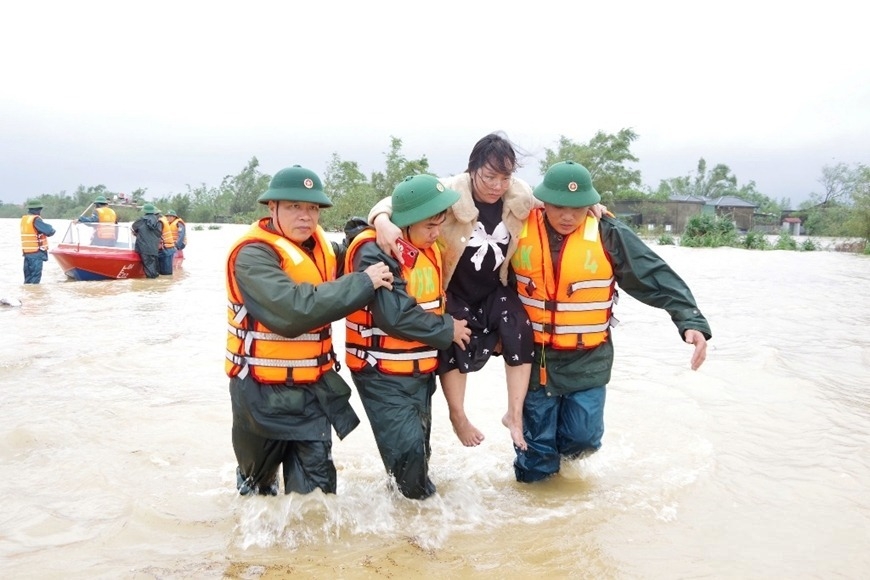 Bộ đội đưa một thai phụ ở vùng ngập lụt đến nơi an toàn.