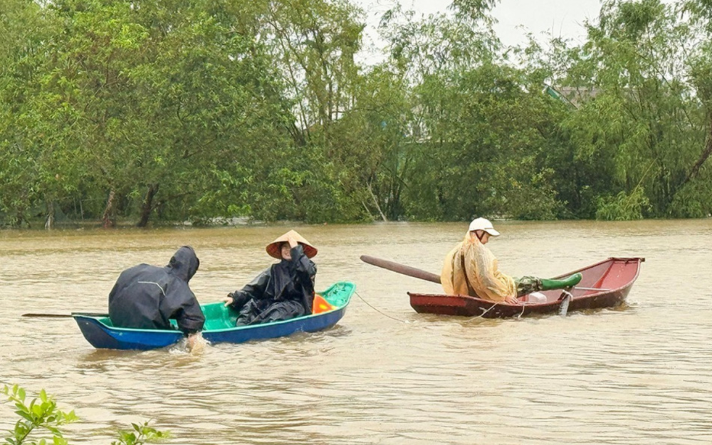 Đường ngập sâu, người dân dùng thuyền nhỏ di chuyển trong ngày mưa lớn.