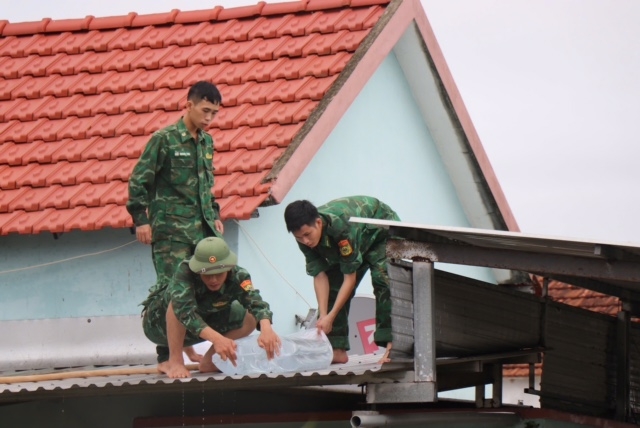 Bộ đội Biên phòng tỉnh Quảng Ngãi giúp dân chằng chống nhà cửa trước bão.