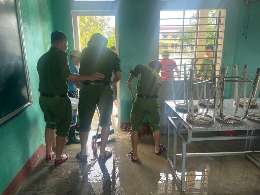 Các chiến sĩ công an dọn bùn đất tại các lớp học