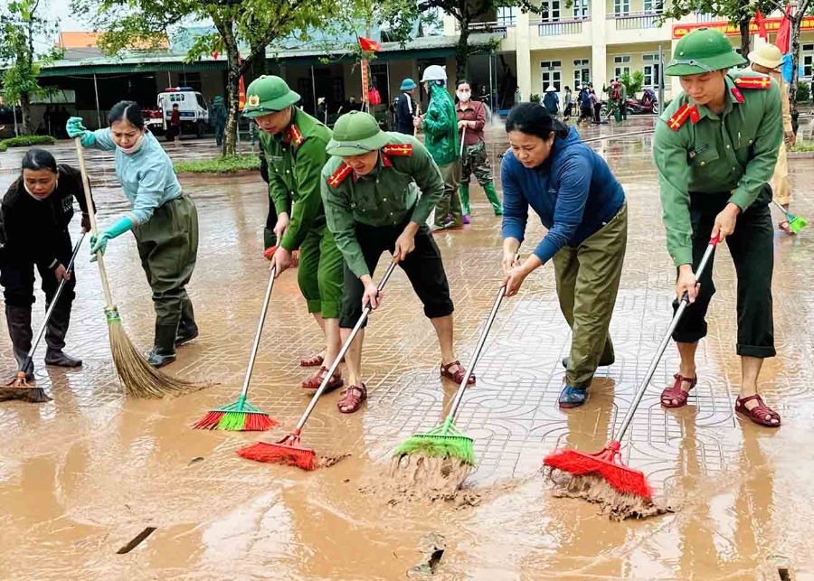 Công an giúp dọn bùn ở Trường THCS Mỹ Duệ