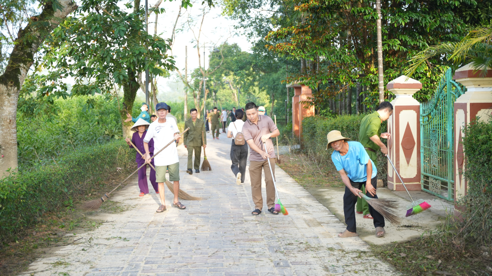 Nhân dân phường Phong Dinh và các lực lượng đang dọn dẹp tại trục đường chính dẫn vào Làng cổ Phước Tích. 