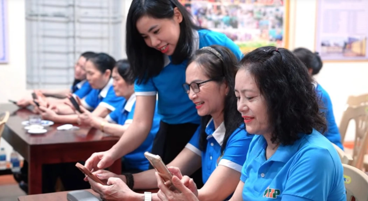 Cán bộ Hội LHPN phường Bỉm Sơn (Thanh Hóa) hướng dẫn hội viên sử dụng các ứng dụng trên điện thoại thông minh. Ảnh: An Nhi