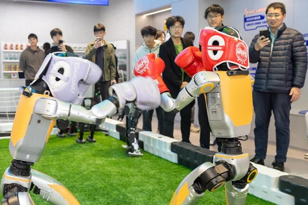 Khách hàng quan sát hai robot đấu boxing. (Nguồn ảnh: Optics Valley of China)