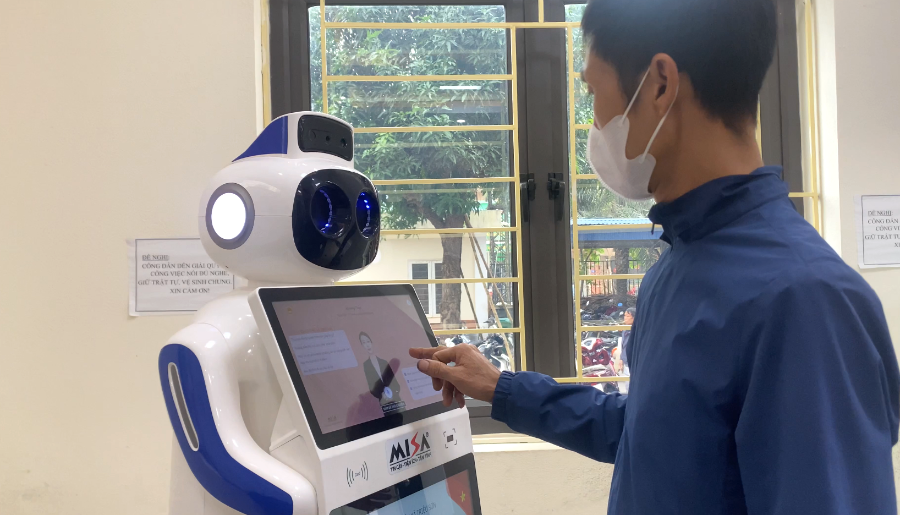 Người dân thao tác giao tiếp với robot lễ tân tích hợp trí tuệ nhân tạo tại Trung tâm Phục vụ hành chính công xã Triệu Sơn