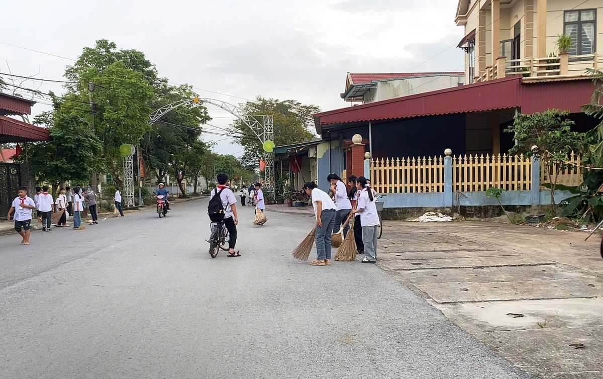 Các em học sinh trường dọn dẹp vệ sinh đường làng, ngõ xóm tại xã Thọ Phú.