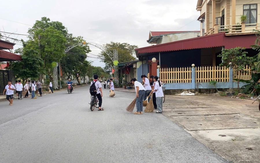 Các em học sinh trường dọn dẹp vệ sinh đường làng, ngõ xóm tại xã Thọ Phú.
