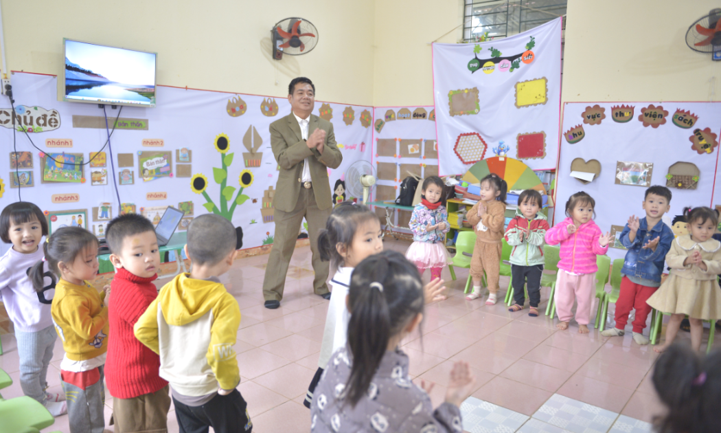 Thầy Lương Văn Sắng đang dạy các em nhỏ hát múa tại lớp học Trường mầm non Văn Nho.