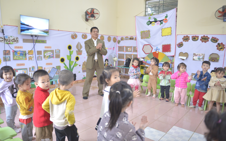 Thầy Lương Văn Sắng đang dạy các em nhỏ hát múa tại lớp học Trường mầm non Văn Nho.
