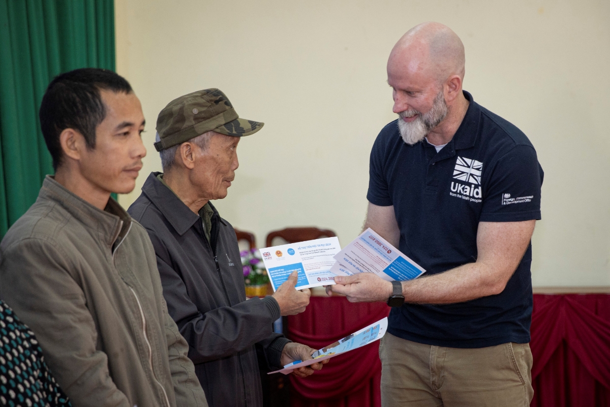Ông Fergus McBean, Bí thư Thứ nhất phụ trách Khí hậu và Thiên nhiên (Đại sứ quán Anh) trao tiền hỗ trợ cho các hộ gia đình bị ảnh hưởng bởi bão lũ vừa qua tại Lạng Sơn. (Ảnh: UNICEF)