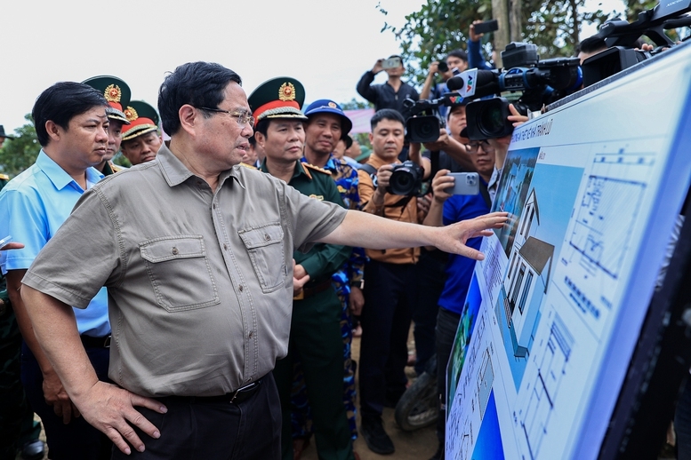 Thủ tướng Phạm Minh Chính nghe báo cáo về thiết kế nhà chống lũ - Ảnh: VGP