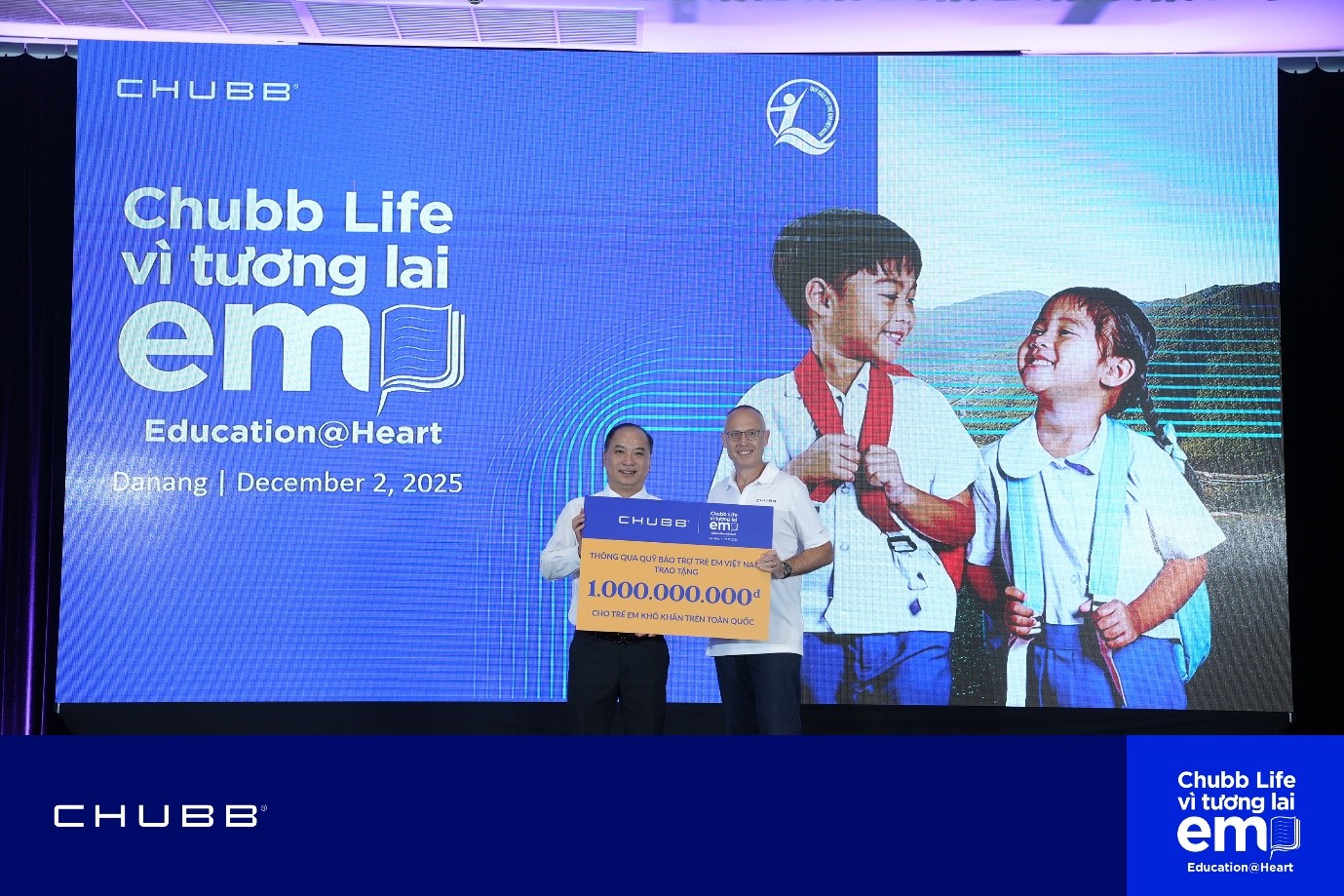 Ông Bryce Johns, Phó Chủ tịch Cấp cao Tập đoàn Chubb & Chủ tịch Chubb Life Toàn cầu (bìa phải) trao biểu trưng 1 tỷ đồng cho ông Đinh Tiến Hải, Giám đốc Quỹ Bảo trợ Trẻ em Việt Nam (bìa trái), khẳng định cam kết bền bỉ của Chubb Life đối với giáo dục và cộng đồng.