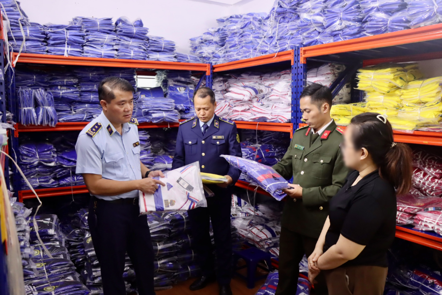 Lực lượng chức năng kiểm tra tại cơ sở kinh doanh quần áo thể thao trên phố Hoàng Công Chất, phường Phú Diễn, Hà Nội.