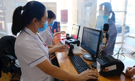 Nhân viên y tế thực hiện quét mã QR trên căn cước công dân của bệnh nhân. khi tới khám. Ảnh: Hoàng Dương