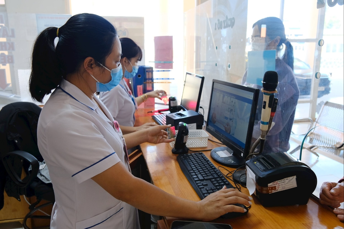 Nhân viên y tế thực hiện quét mã QR trên căn cước công dân của bệnh nhân. khi tới khám. Ảnh: Hoàng Dương