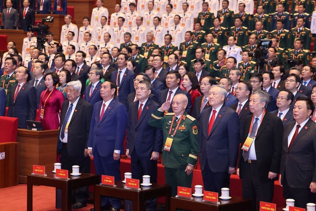 Các đồng chí lãnh đạo, nguyên lãnh đạo Đảng, Nhà nước và đại biểu thực hiện nghi lễ chào cờ. Ảnh: TTXVN