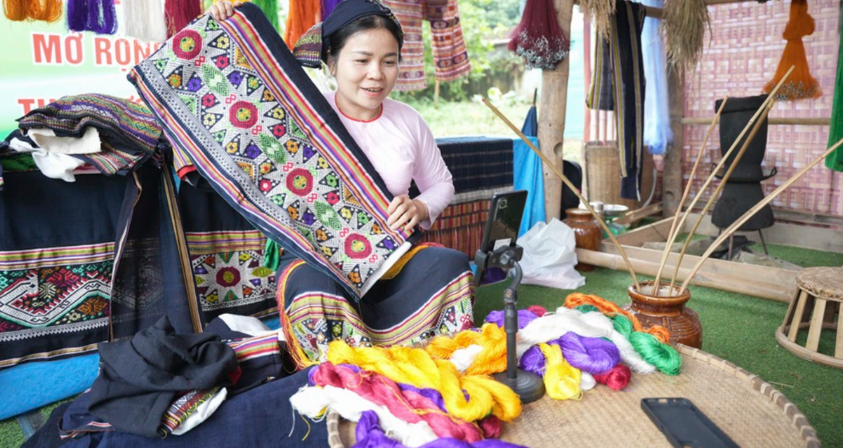 Bà Vi Thị Luyến, Tổ trưởng Tổ dệt thổ cẩm Táy Dó bản Bèn (xã Xuân Chinh, Thanh Hóa), livestream bán các sản phẩm thổ cẩm truyền thống của đồng bào người Thái