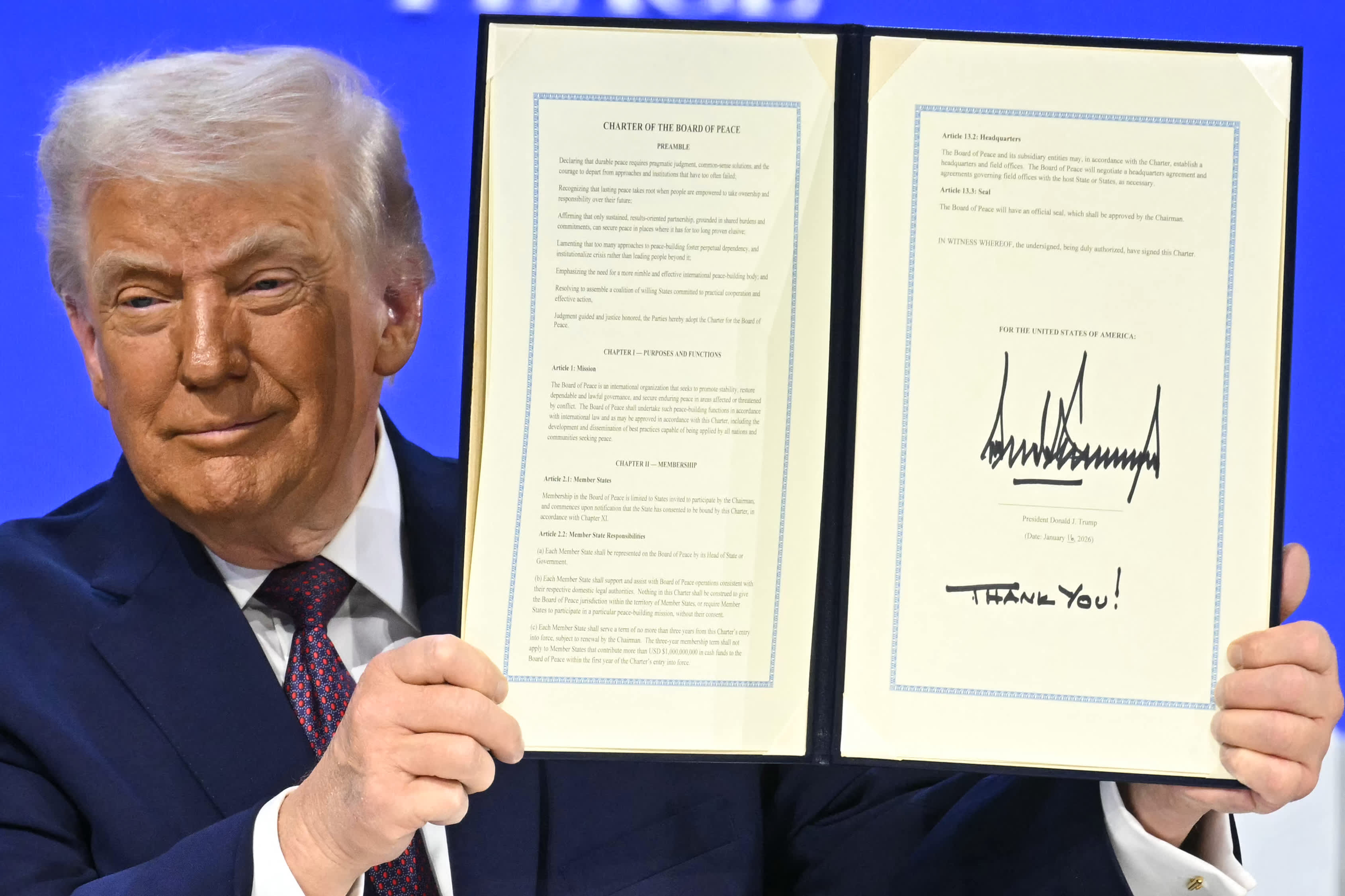 Tổng thống Mỹ Donald Trump giơ bản hiến chương sáng lập vừa ký tại lễ ký “Hội đồng Hòa bình” (Board of Peace) bên lề Diễn đàn Kinh tế Thế giới (WEF) ngày 22/1/2026 ở Davos, Thụy Sỹ - Ảnh: Getty Images