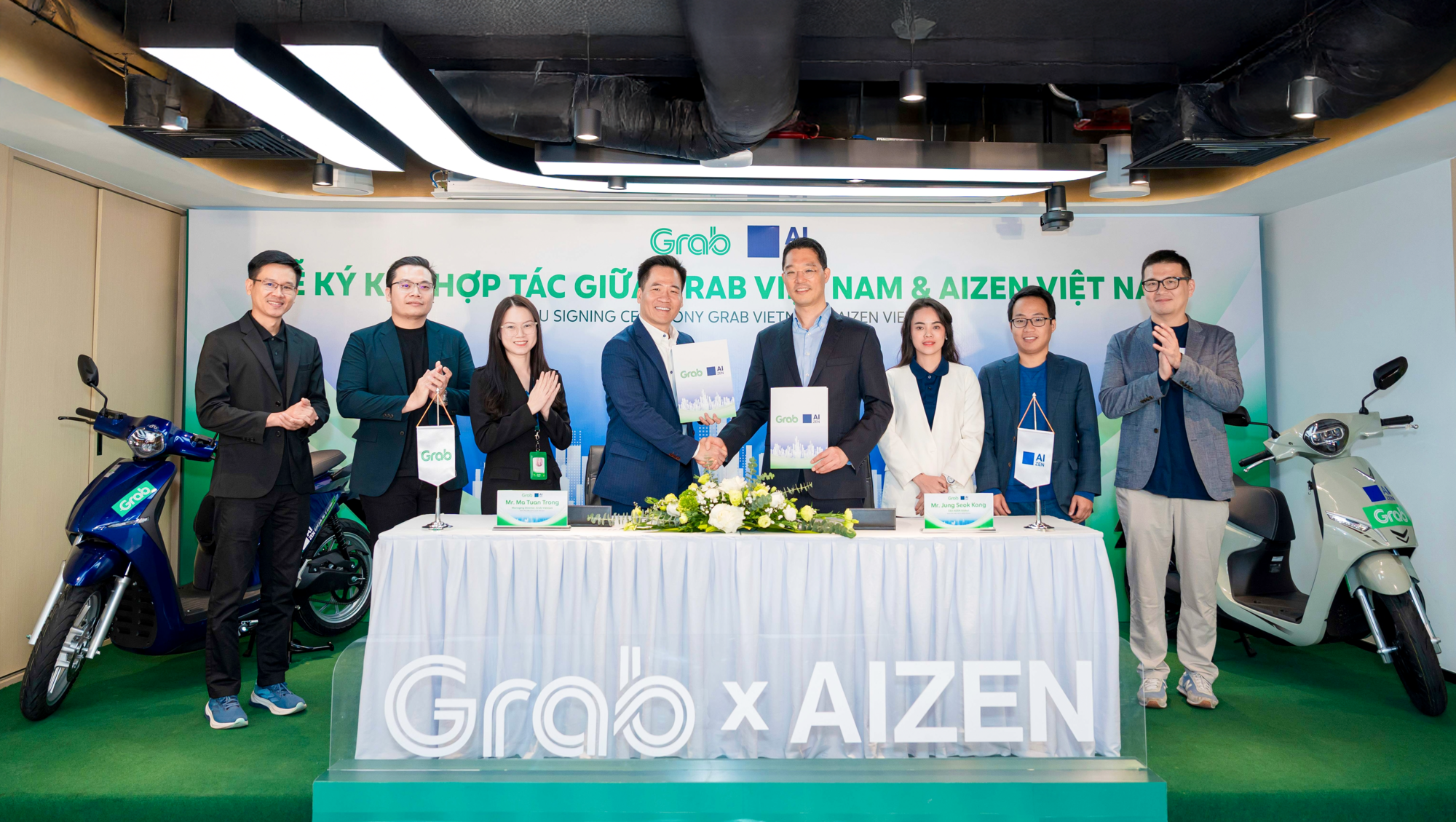 Đại diện Grab Việt Nam và AIZEN Việt Nam ký kết thoả thuận hợp tác.Ảnh: Grab Việt Nam.