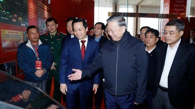 Tổng Bí thư Tô Lâm và các đại biểu tham quan không gian trưng bày ảnh về Ban Chấp hành Đảng bộ tỉnh Cao Bằng. Ảnh: TTXVN.