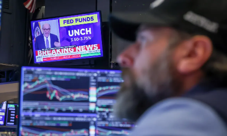 Một nhà giao dịch trên sàn NYSE ở New York làm việc cạnh màn hình đang phát bản tin về cuộc họp Fed ngày 28/1/2026 - Ảnh: Reuters.
