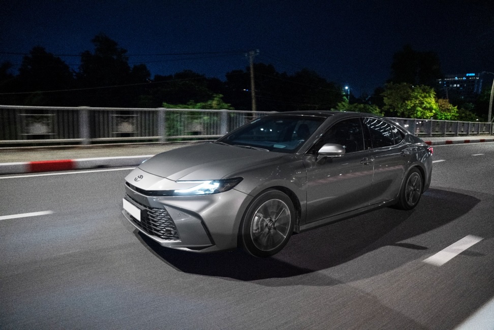 <i>Camry HEV 2025 còn sở hữu diện mạo vừa thanh lịch vừa thể thao, theo ngôn ngữ thiết kế TNGA toàn cầu. Phần đầu xe lấy cảm hứng “cá mập đầu búa” mang đến cảm giác mạnh mẽ, uy lực, hiện đại. Cản trước họa tiết kim cương giúp tăng độ sang trọng, tạo chiều sâu thị giác rõ rệt.</i>
