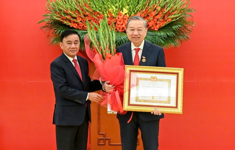 Thường trực Ban Bí thư Trần Cẩm Tú trao huy hiệu 45 năm tuổi đảng, tặng hoa chúc mừng đồng chí Tô Lâm, Tổng Bí thư Ban Chấp hành Trung ương Đảng Cộng sản Việt Nam. Ảnh: Nhân Dân.