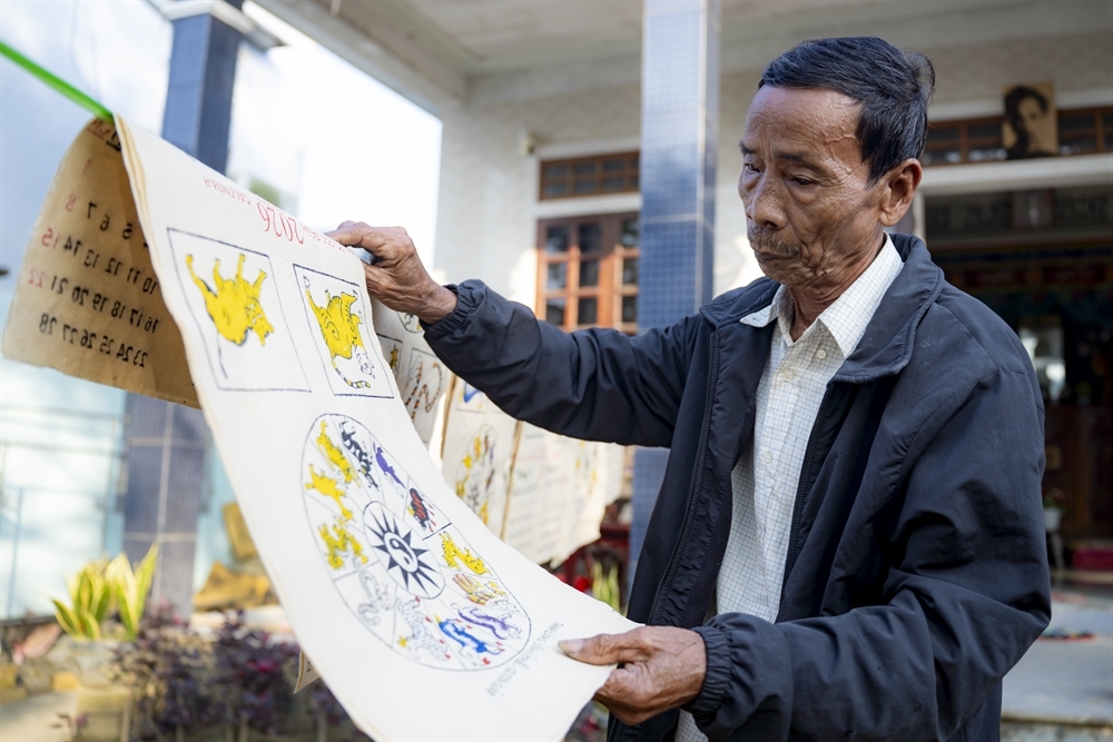 Nghệ nhân Kỳ Hữu Phước phơi tranh dân gian làng Sình.