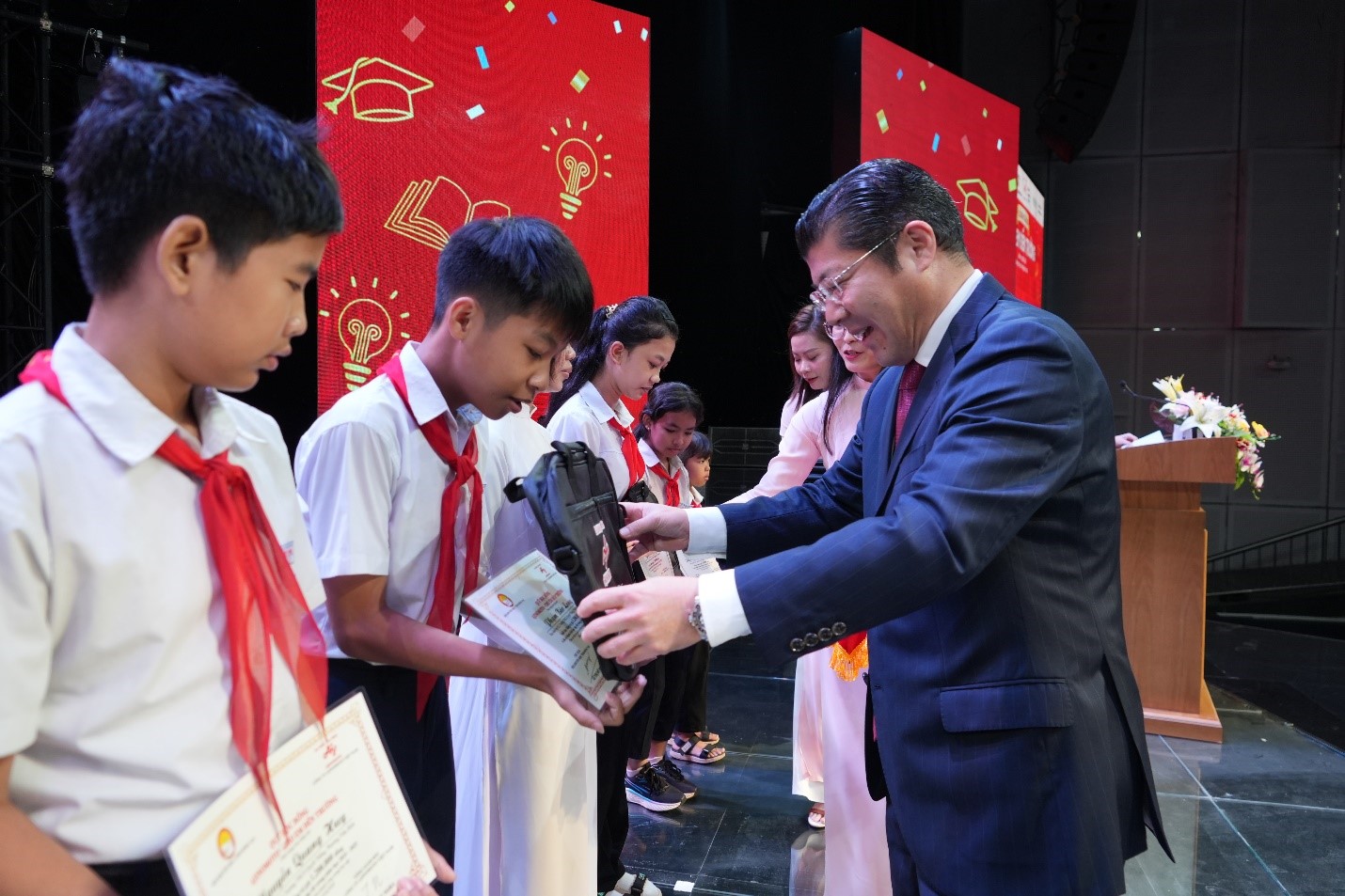 Ông Tsutomu Nara – Tổng giám đốc Công ty Ajinomoto Việt Nam, trao học bổng cho học sinh. Ảnh: Ajinomoto Việt Nam.