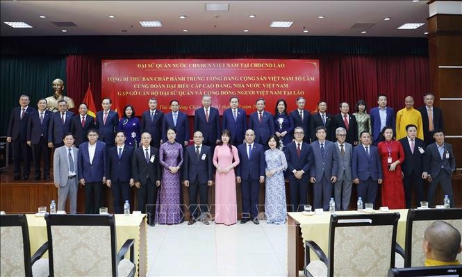 Tổng Bí thư Tô Lâm chụp ảnh lưu niệm với cán bộ Đại sứ quán và cộng đồng người Việt Nam tại Lào. Ảnh: TTXVN.