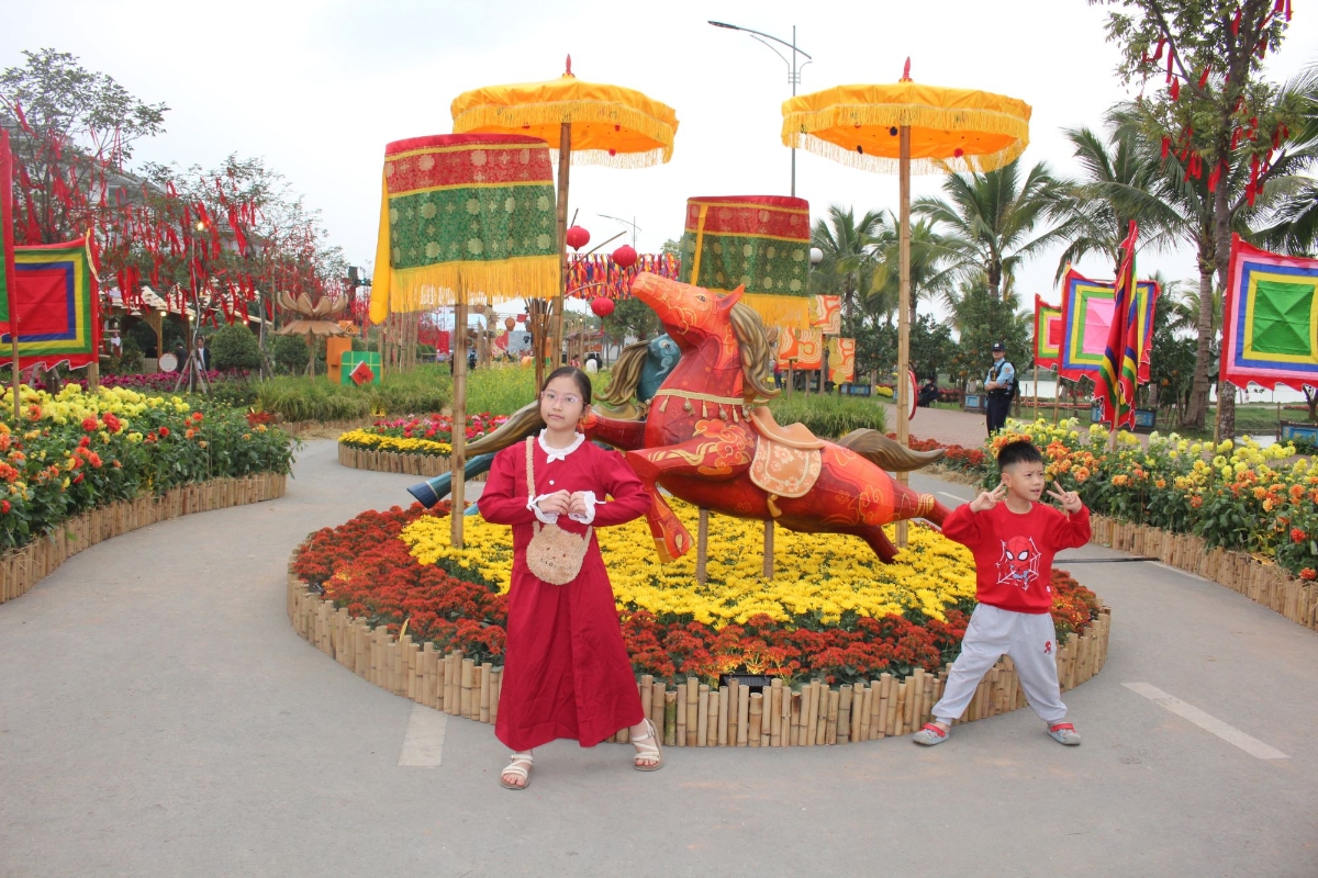 Trẻ em thích thú chơi đùa và chụp ảnh ở đường hoa Xuân tại khu đô thị Mailand Hanoi. Ảnh: Chu Khôi.