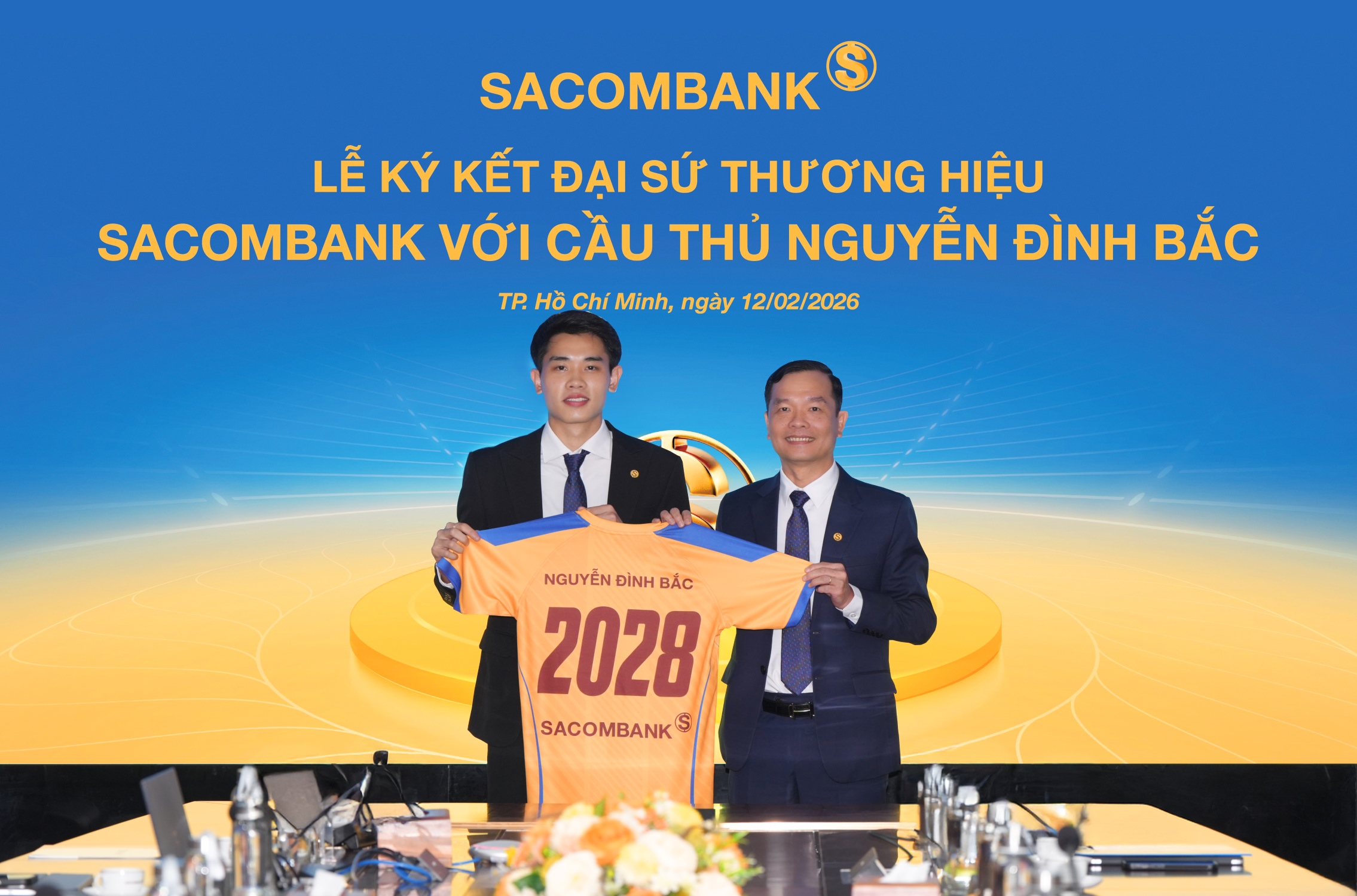 Ông Hà Văn Trung - Phó Tổng giám đốc thường trực SACOMBANK trao trang phục cho Đại sứ thương hiệu Nguyễn Đình Bắc tại buổi lễ ký kết. Ảnh: SACOMBANK.