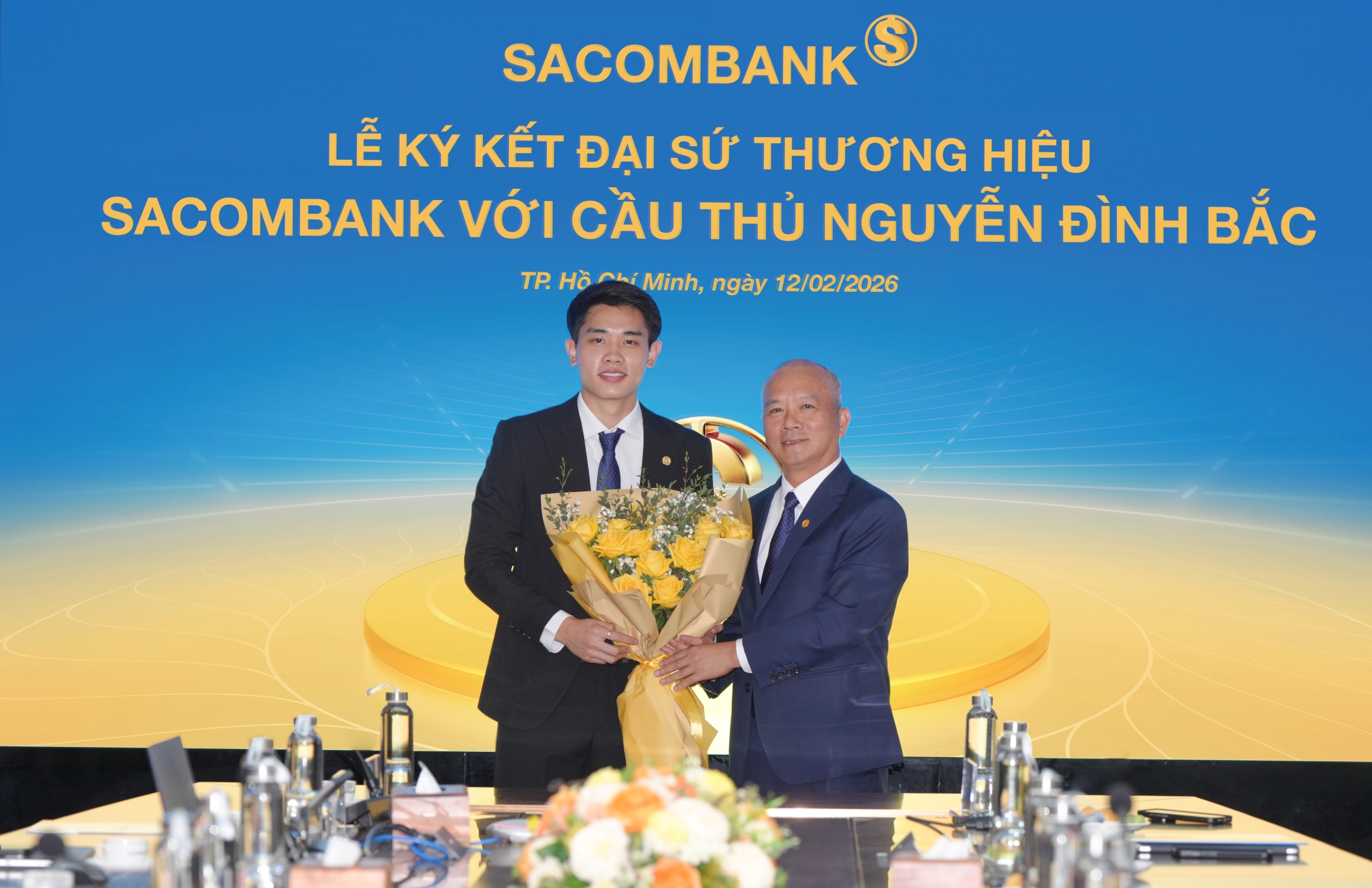Ông Phan Đình Tuệ - Thành viên Hội đồng quản trị SACOMBANK trao hoa chúc mừng cầu thủ tân đại sứ thương hiệu. Ảnh: SACOMBANK.