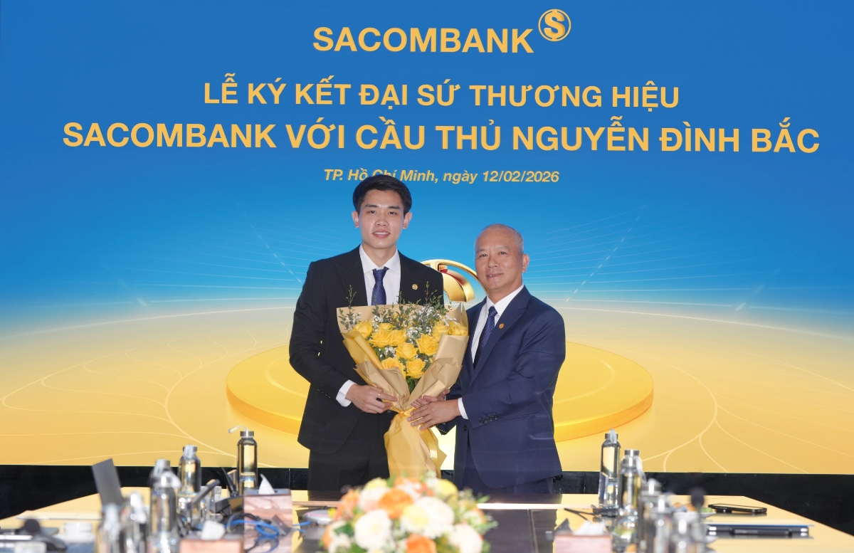 Ông Phan Đình Tuệ - Thành viên Hội đồng quản trị SACOMBANK trao hoa chúc mừng cầu thủ tân đại sứ thương hiệu.&nbsp;Ảnh: SACOMBANK.