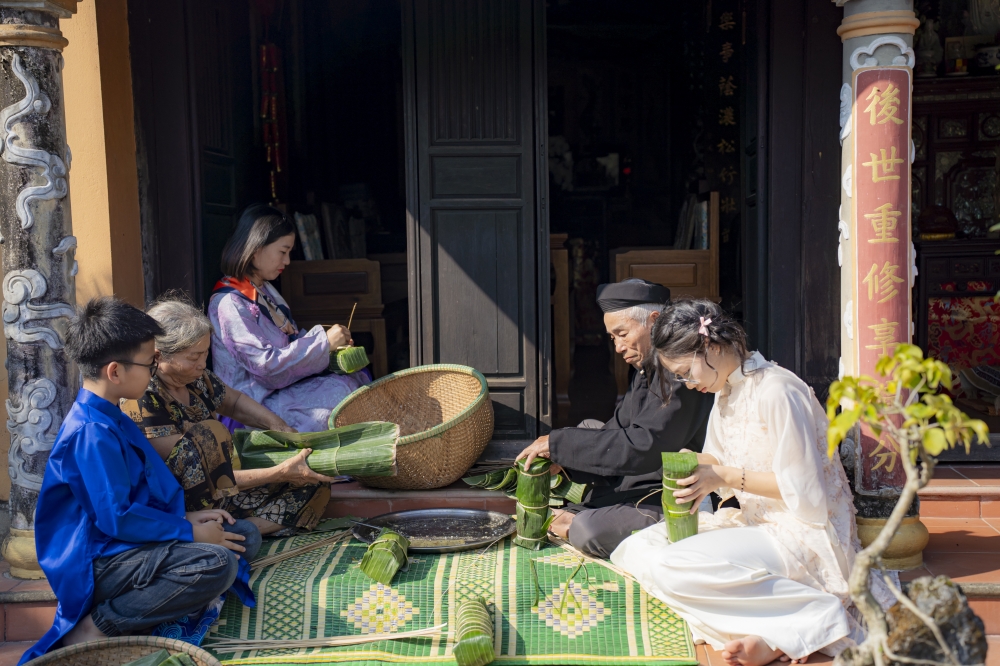 Các thành viên trong gia đình cùng nhau gói bánh, giữ lửa nghề truyền thống
