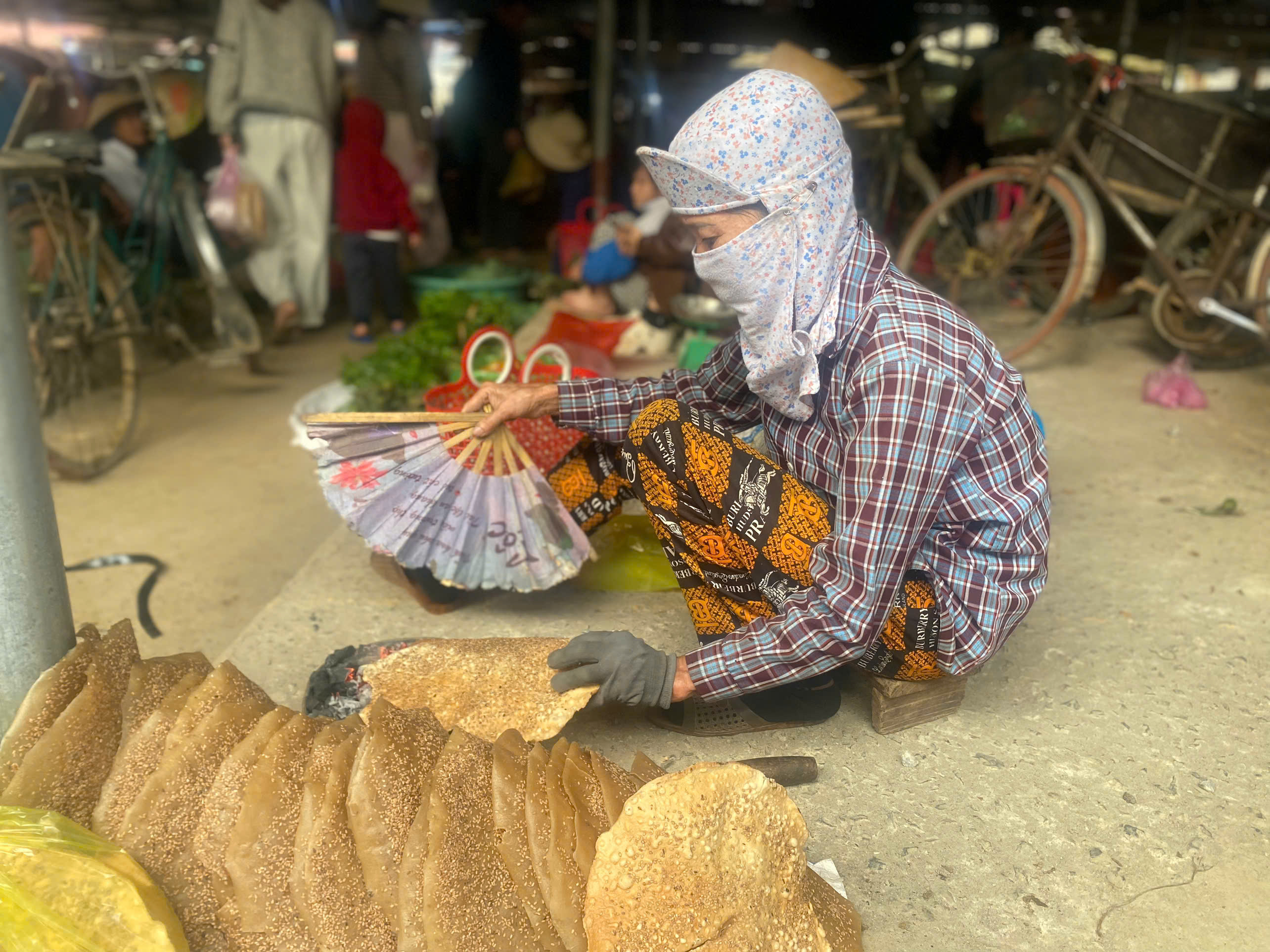 Nướng bánh đa tại các chợ quê là hình ảnh đặc trưng, dân dã với những chiếc bánh đa vừng được quạt trên bếp than củi hồng.
