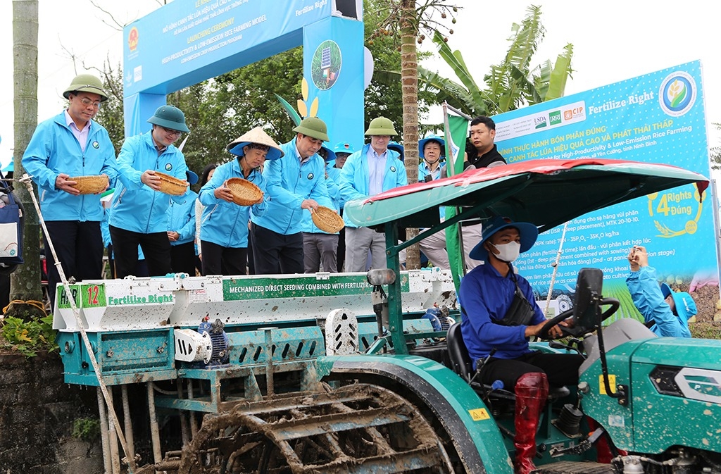 Các đại biểu tham gia đổ giống vào máy sạ hàng kết hợp vùi phân