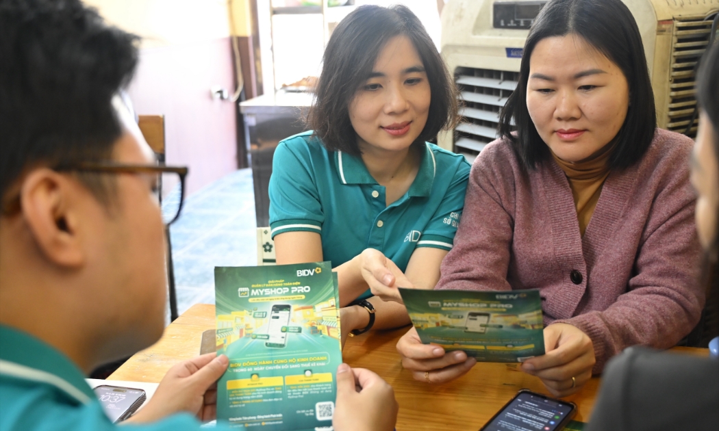 Cán bộ BIDV tư vấn và hỗ trợ hộ kinh doanh cài đặt ứng dụng MyShop Pro. Ảnh: BIDV.