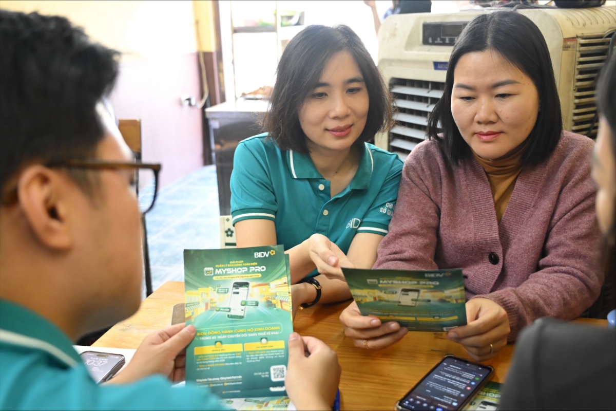 Cán bộ BIDV tư vấn và hỗ trợ hộ kinh doanh cài đặt ứng dụng MyShop Pro. Ảnh: BIDV.